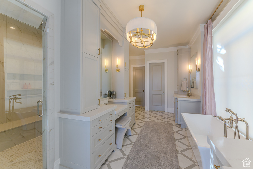 Bathroom with tile patterned flooring, independent shower and bath, ornamental molding, an inviting chandelier, and vanity