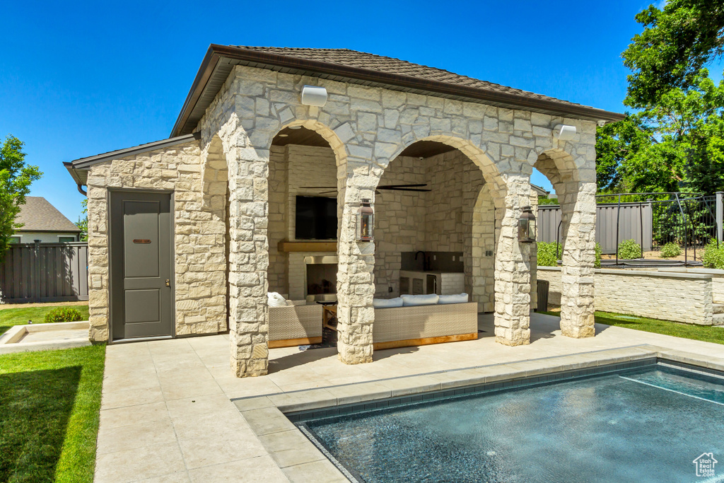 Rear view of house with a fenced in pool, a patio, and a fireplace