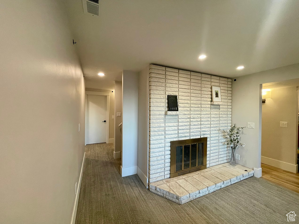 Unfurnished living room featuring carpet and a fireplace