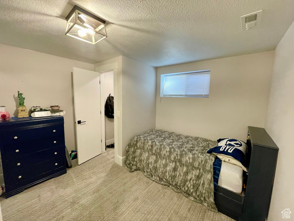 Carpeted bedroom featuring a textured ceiling