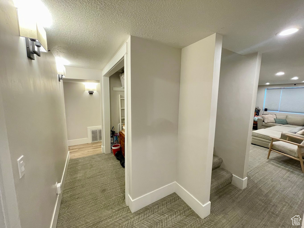 Hall with a textured ceiling and carpet flooring