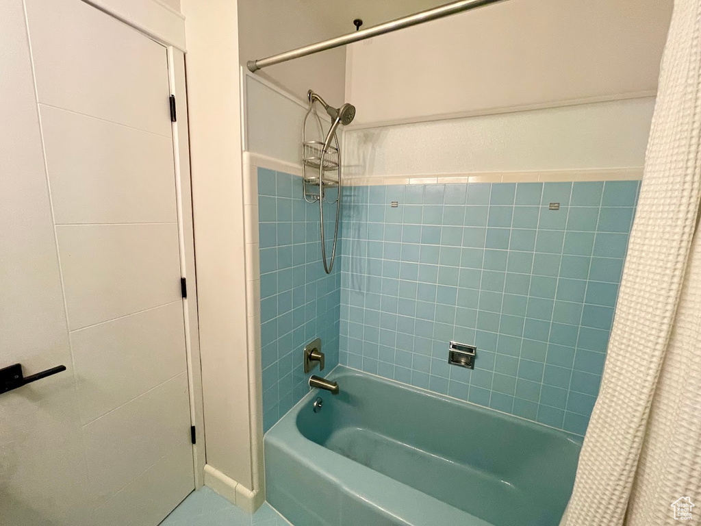 Bathroom with shower / bath combo with shower curtain and tile patterned floors