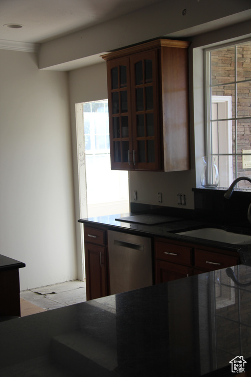 Kitchen with stainless steel dishwasher, sink, and crown molding