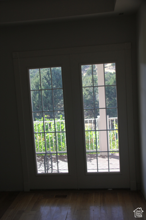 Doorway with a wealth of natural light, wood-type flooring, and french doors