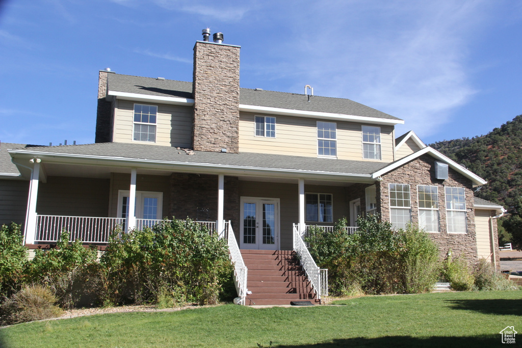 View of front of home with a porch and a front yard