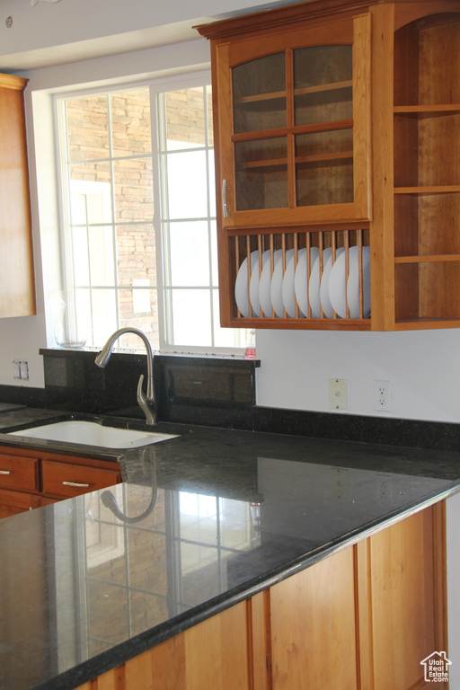 Kitchen featuring sink and dark stone countertops