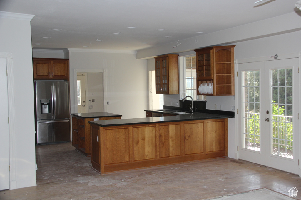 Kitchen featuring french doors, kitchen peninsula, plenty of natural light, and stainless steel fridge