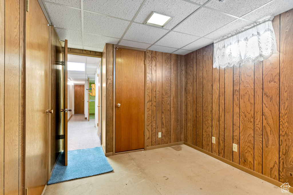 Spare room featuring a paneled ceiling and wood walls