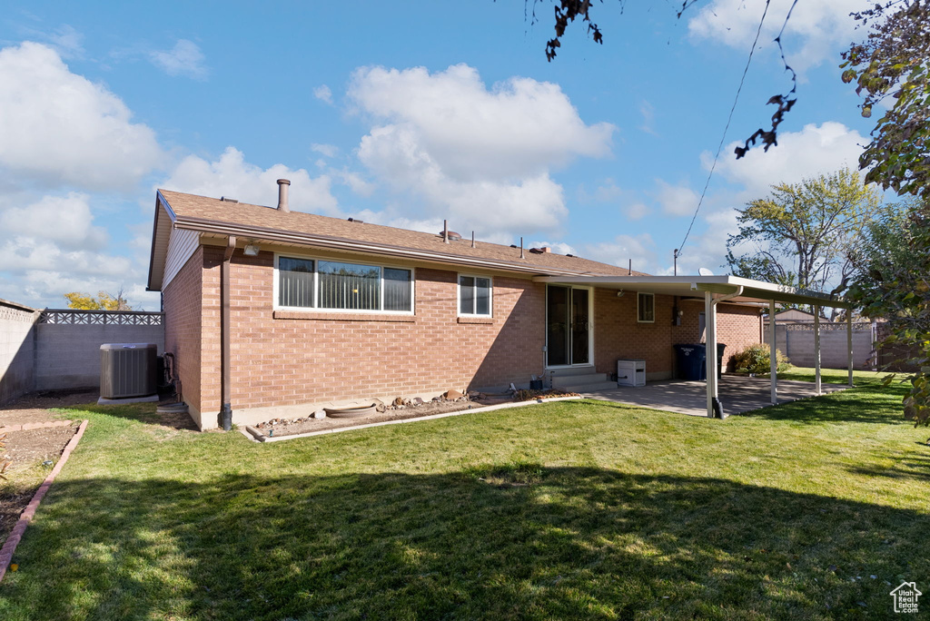 Back of house featuring a patio, a yard, and cooling unit