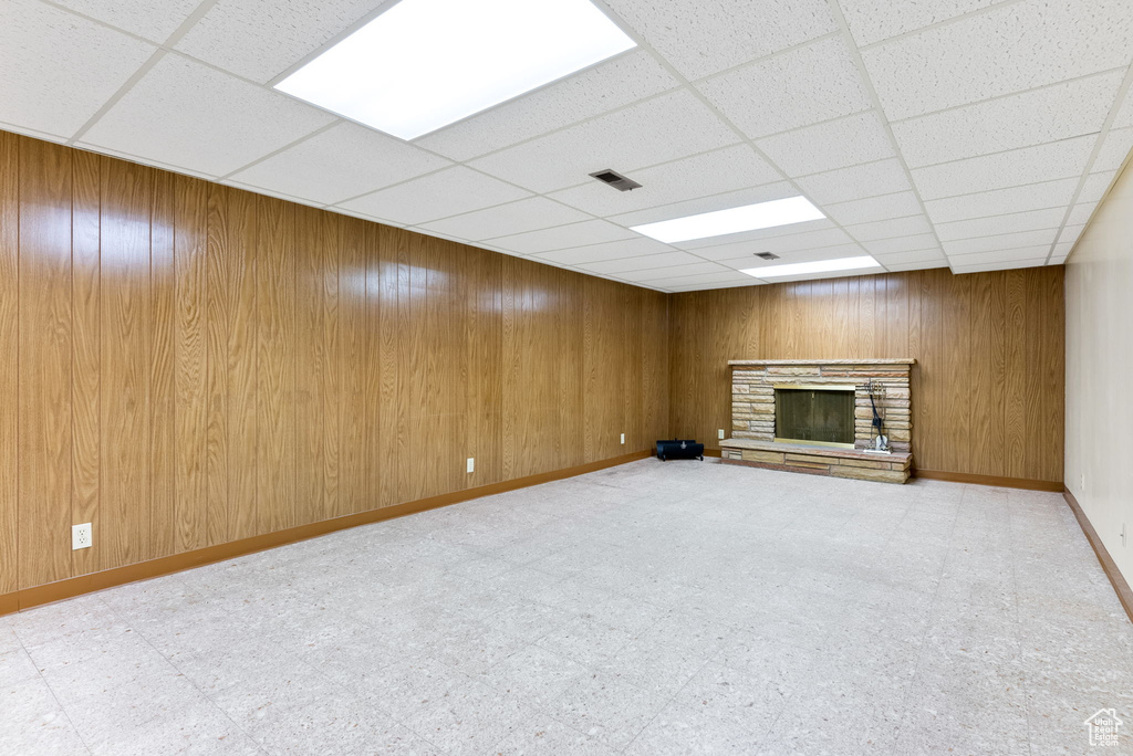 Basement featuring a paneled ceiling and wooden walls