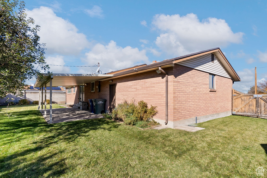 View of property exterior with a patio area and a yard