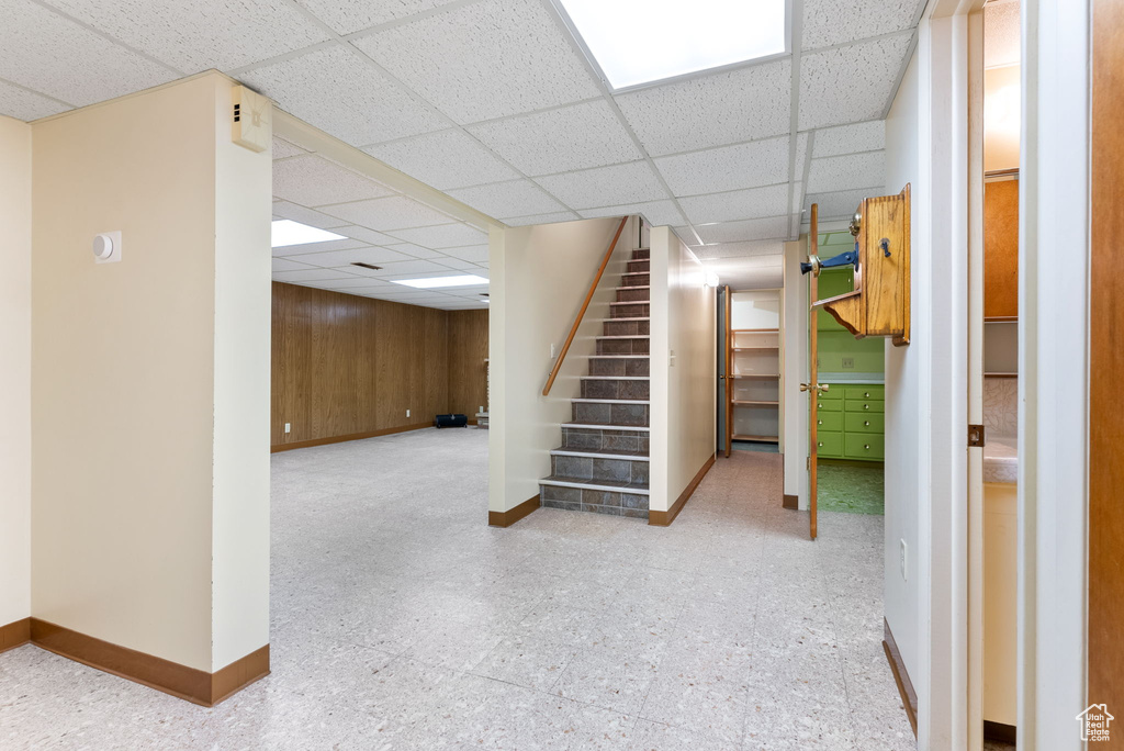 Basement with wood walls and a drop ceiling