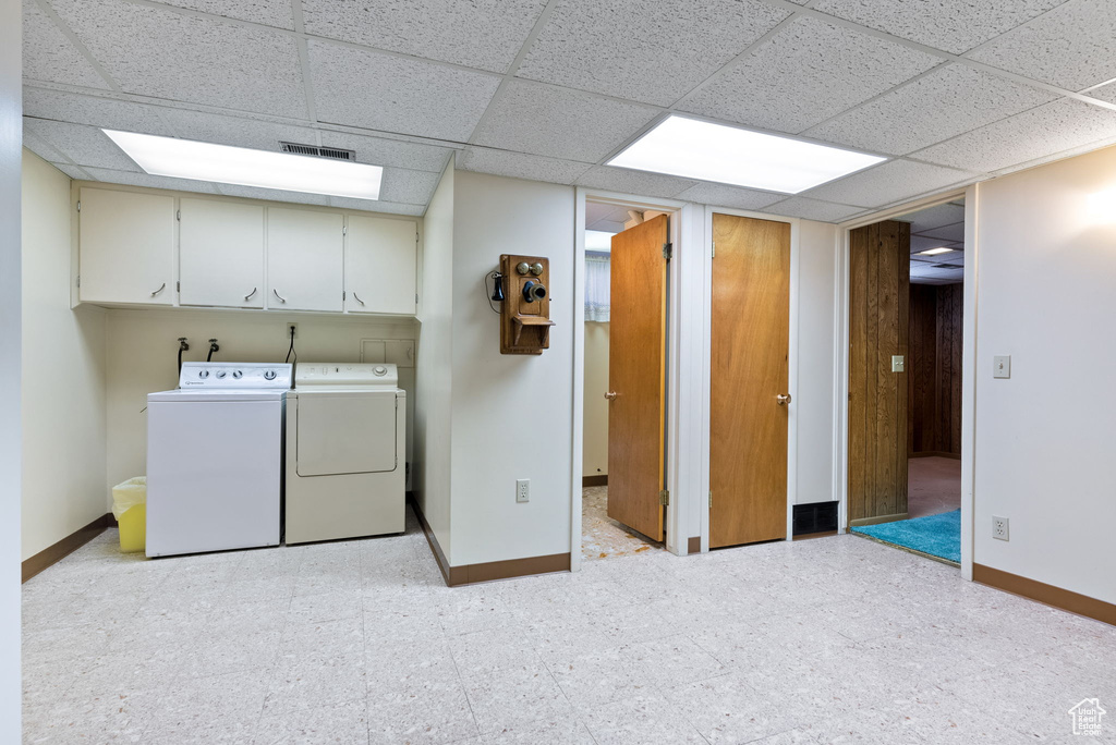 Washroom with washer and clothes dryer and cabinets