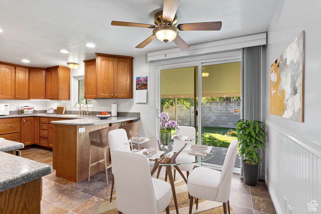 Kitchen with ceiling fan, sink, a breakfast bar, and kitchen peninsula