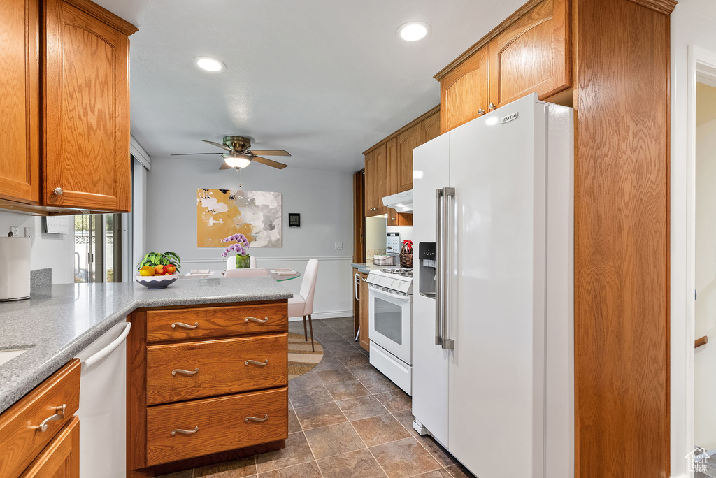 Kitchen featuring kitchen peninsula, white appliances, and ceiling fan