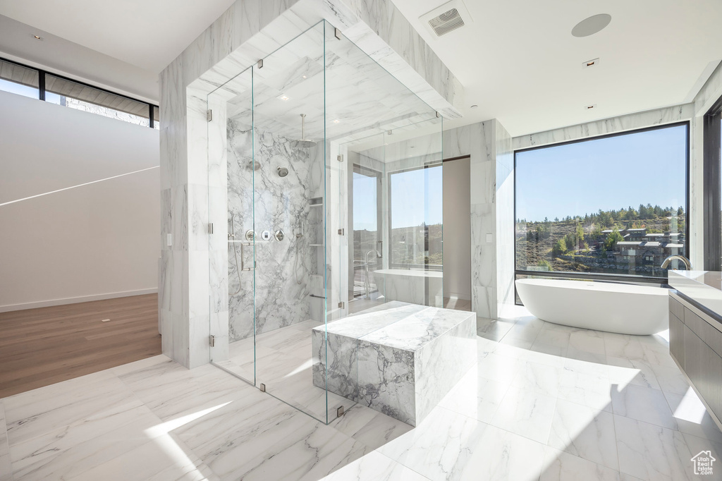Bathroom with a marble finish shower and a soaking tub