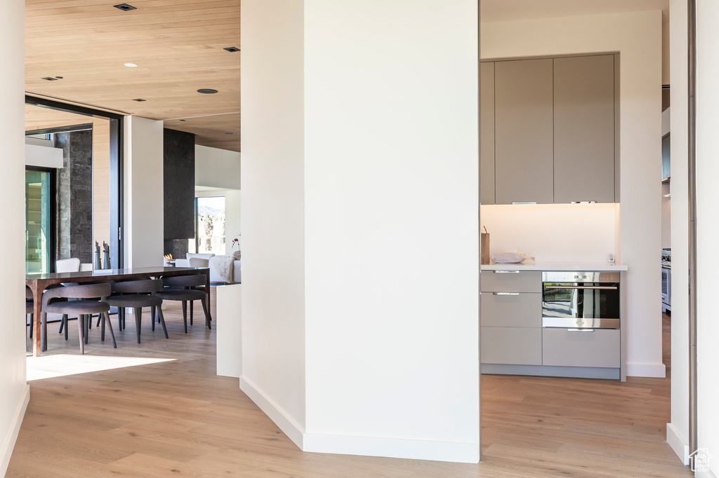 Hall with light wood-type flooring, baseboards, and wooden ceiling