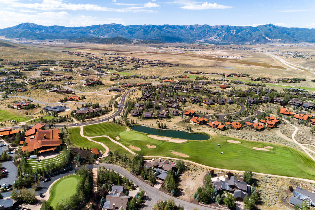 Aerial view of residential area featuring a golf course and a water and mountain view