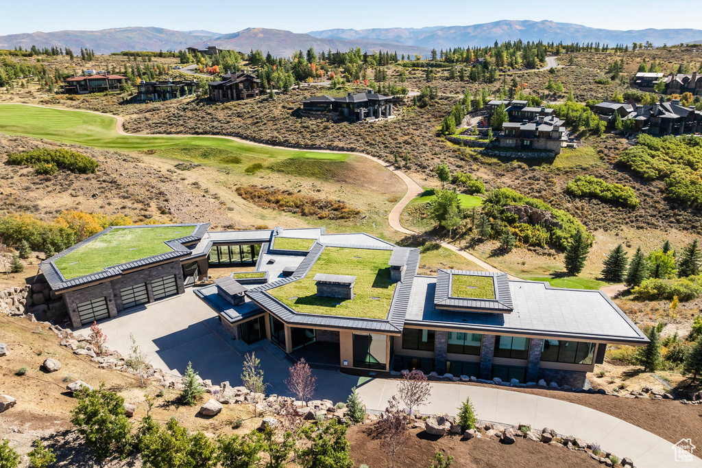 View of subject property with a mountainous background and a golf course