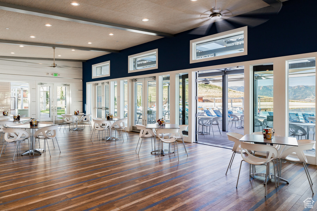 Dining room with a ceiling fan, recessed lighting, wood finished floors, a high ceiling, and beamed ceiling