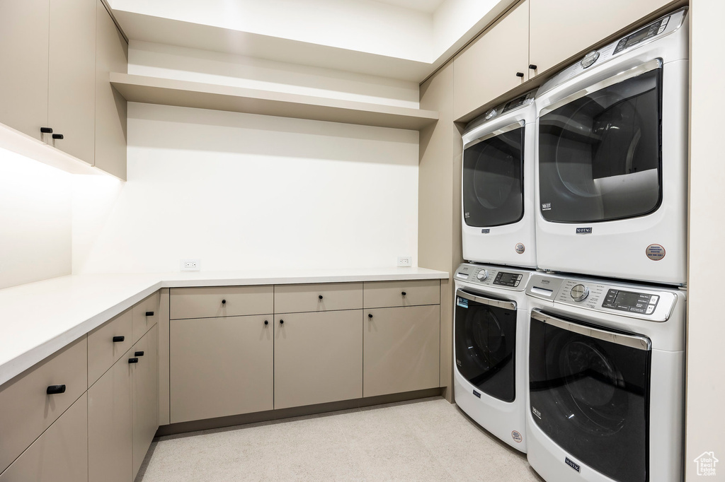 Laundry room with stacked washer / dryer and cabinet space