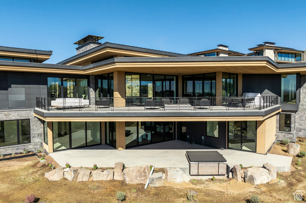Rear view of property with a balcony and a patio area
