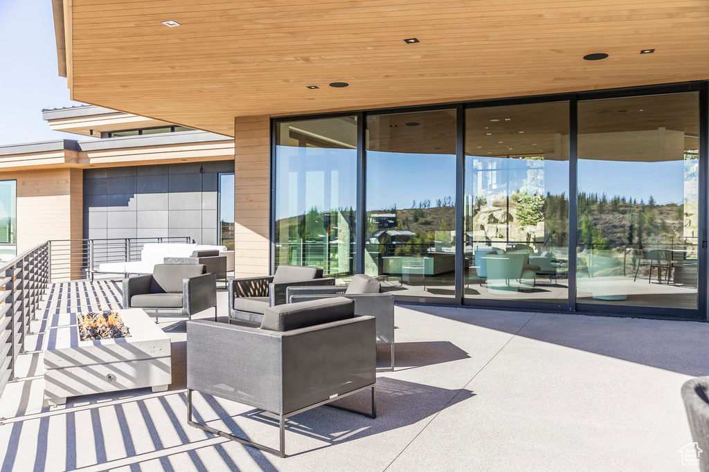 View of patio with an outdoor living space with a fire pit
