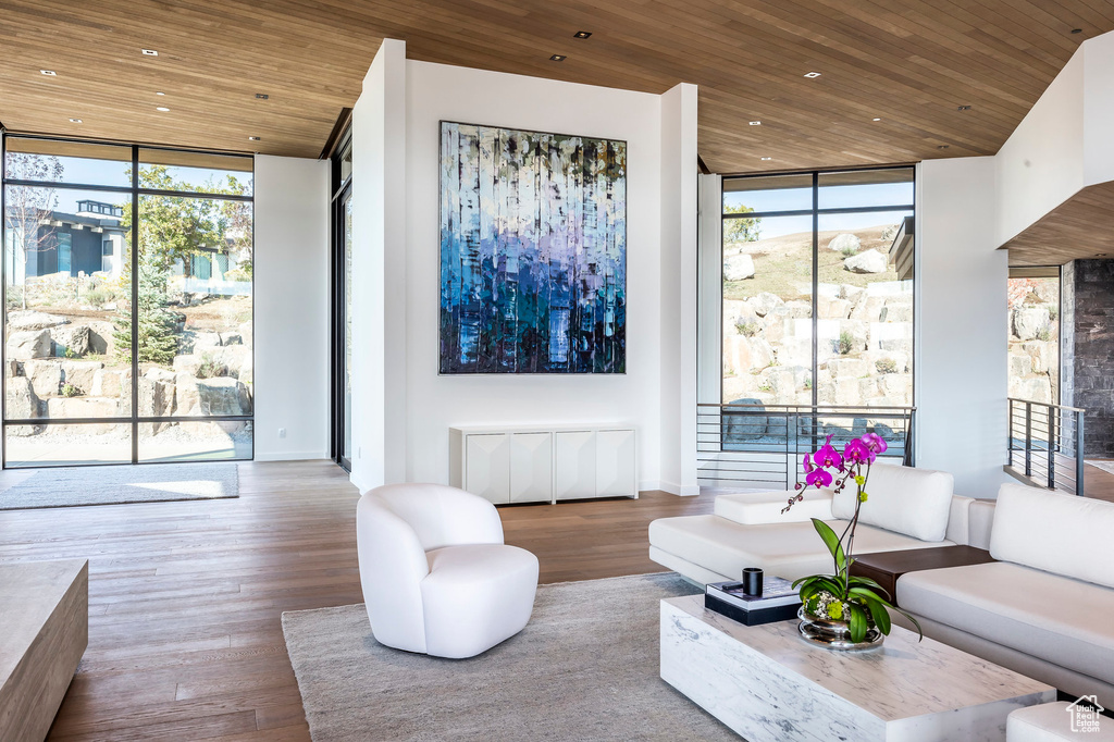 Living room featuring a wall of windows, wooden ceiling, plenty of natural light, wood finished floors, and recessed lighting