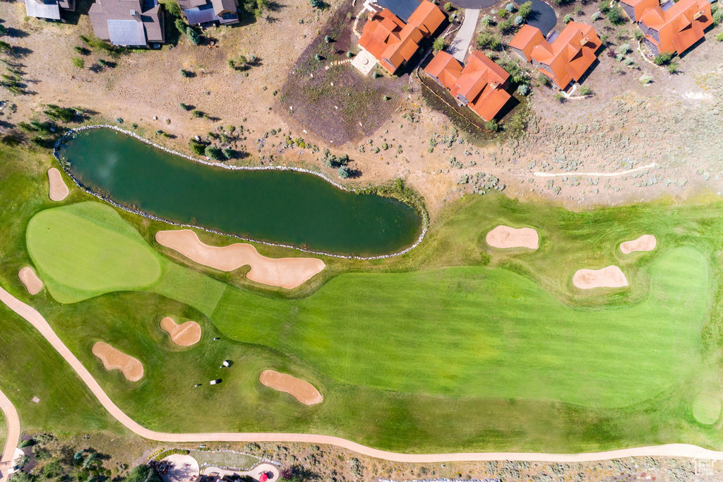 View of property location with a nearby body of water, a local golf course, and nearby suburban area