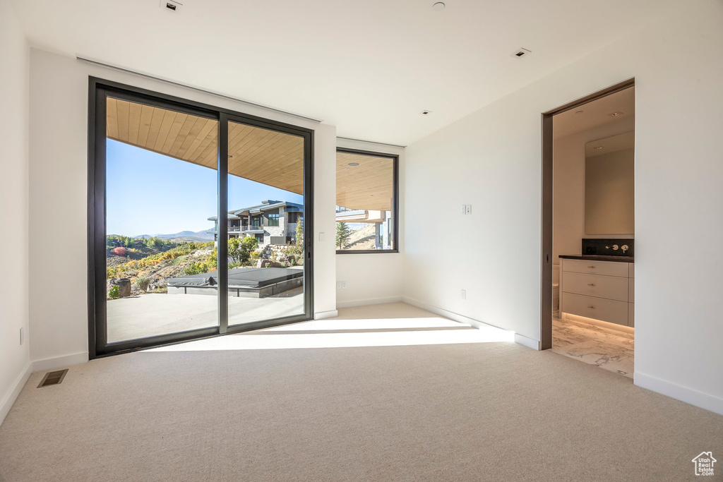 Carpeted empty room featuring baseboards and a mountain view