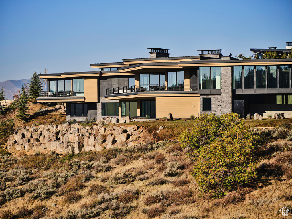 Rear view of house with a mountain view and a balcony