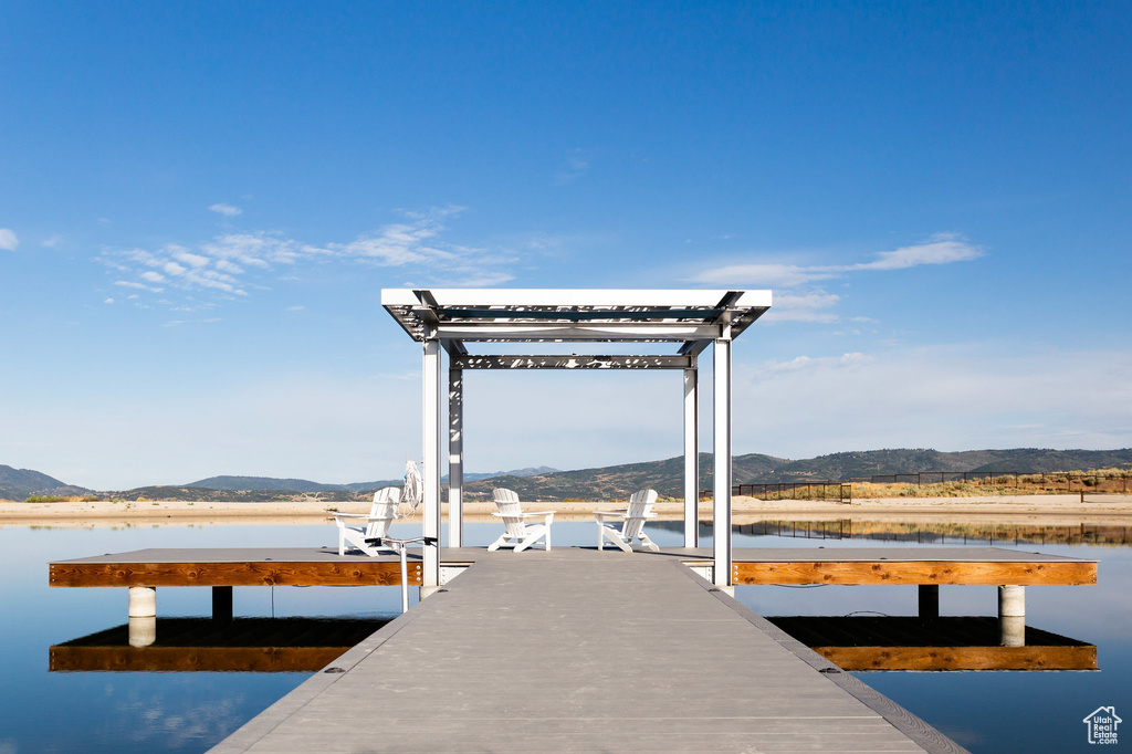 Dock area featuring a water and mountain view