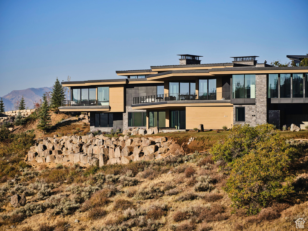 Rear view of property featuring a balcony and a mountain view