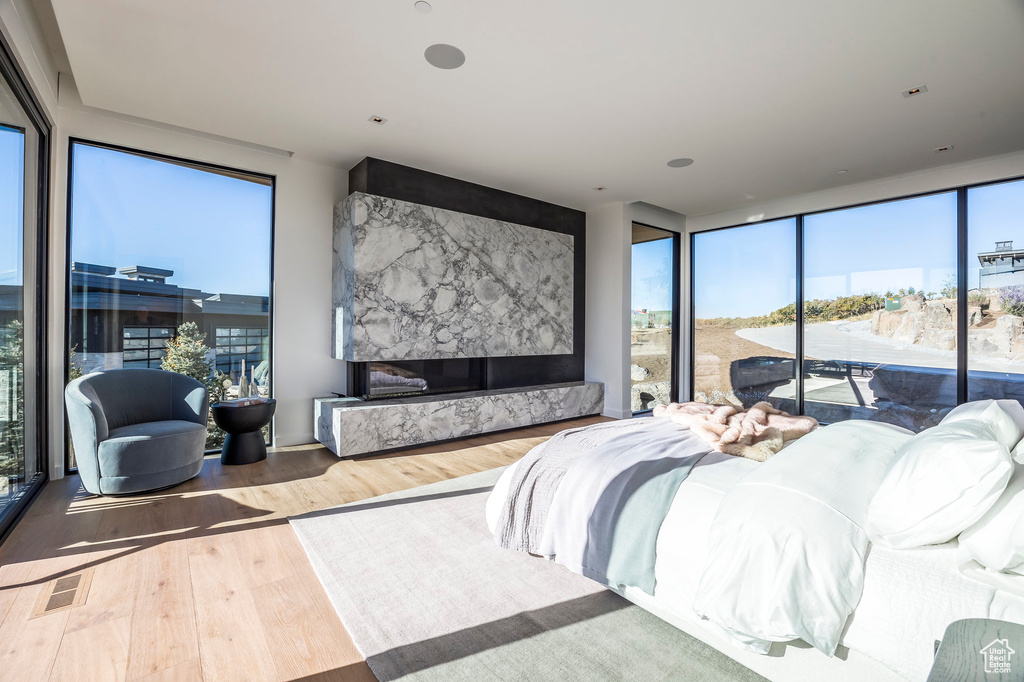 Bedroom with wood finished floors, multiple windows, and access to outside