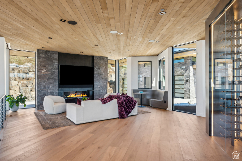Living room with wood ceiling, expansive windows, wood finished floors, a fireplace, and recessed lighting