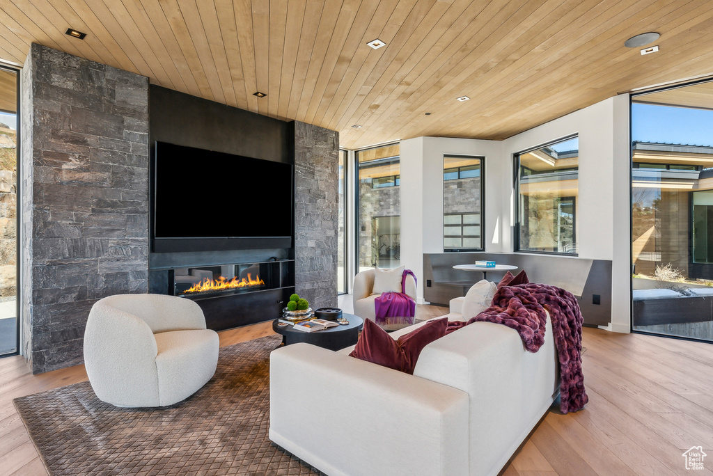 Living room with wood finished floors, wood ceiling, recessed lighting, and a fireplace