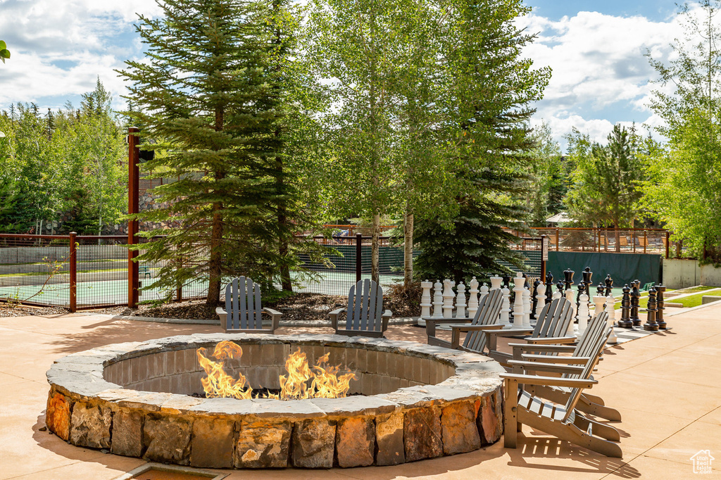 View of property's community with an outdoor fire pit and fence