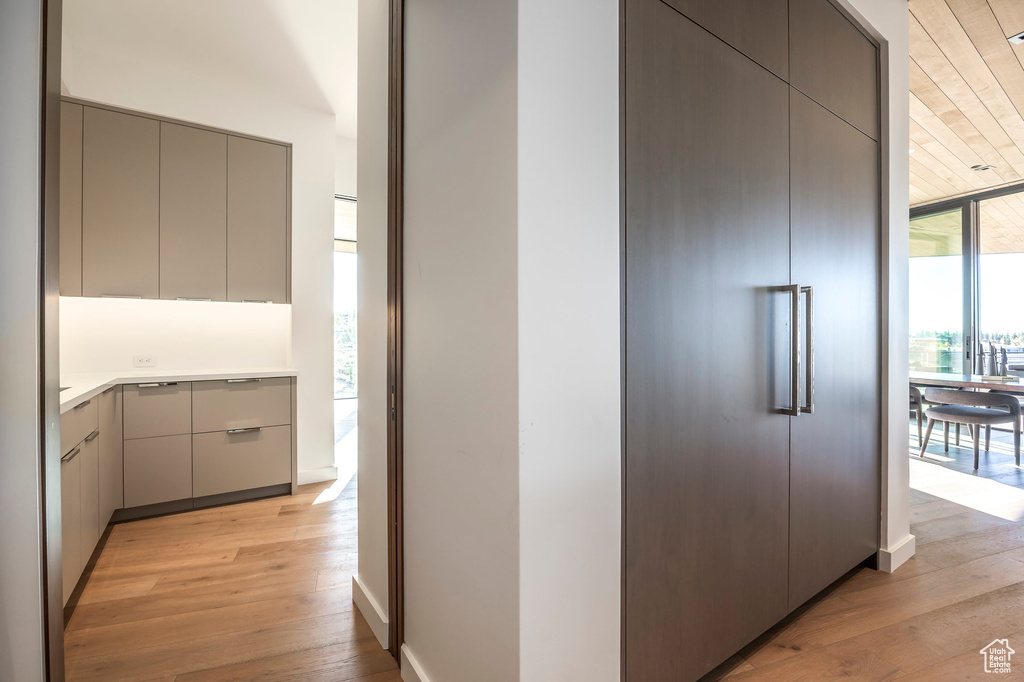 Corridor with light wood-style floors and expansive windows
