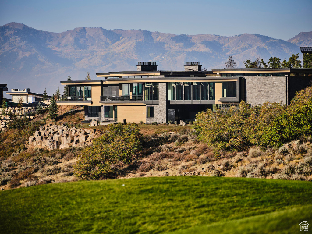 Rear view of property featuring a mountain view and a balcony