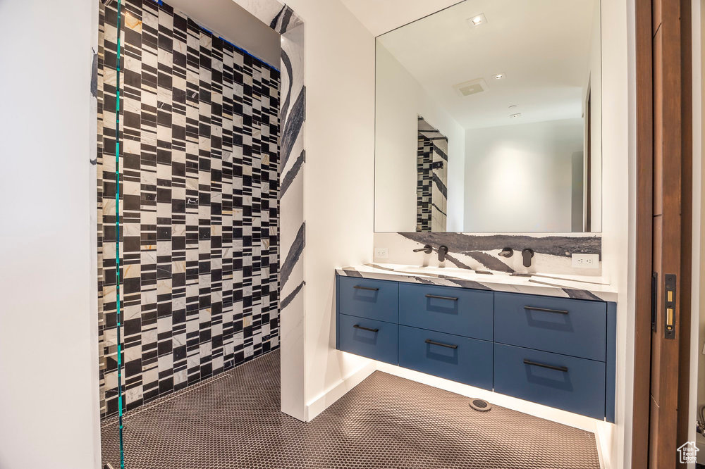 Bathroom featuring double vanity and a tile shower
