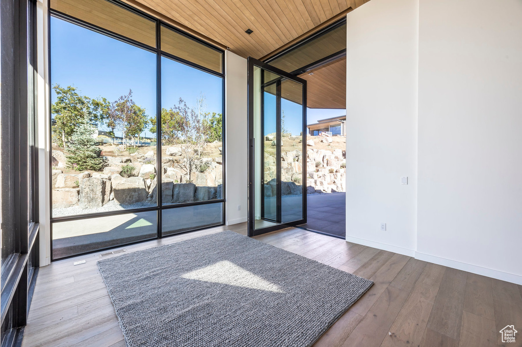 Spare room featuring expansive windows, wooden ceiling, wood finished floors, and baseboards