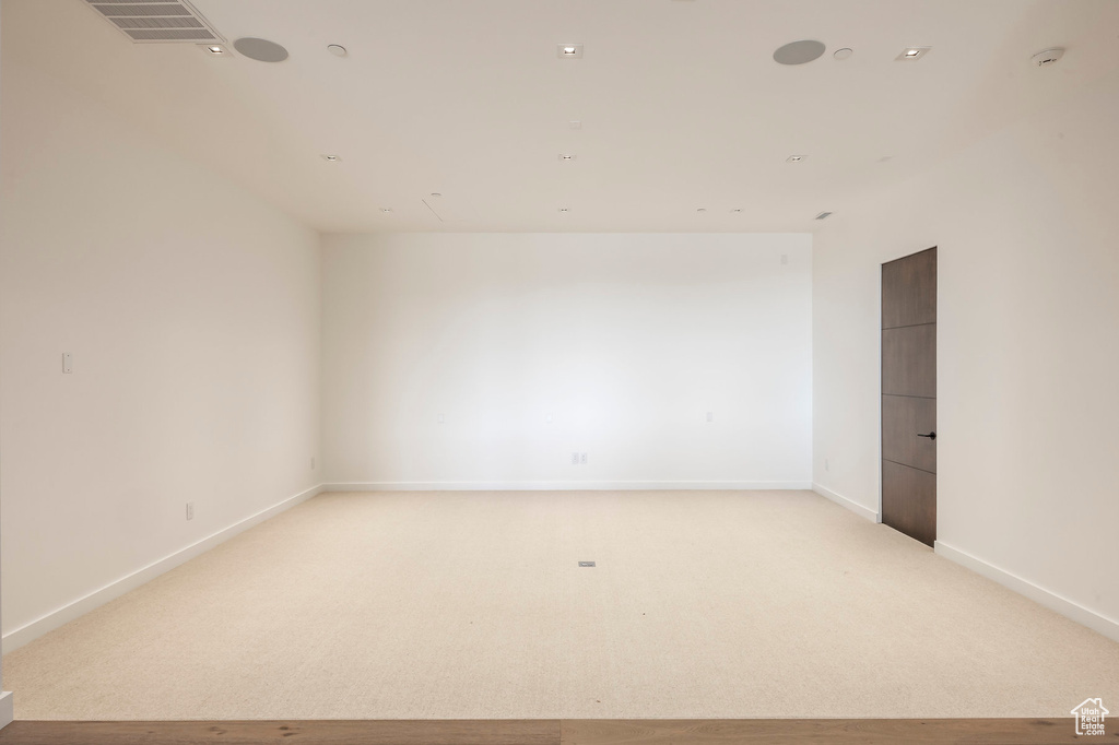 Unfurnished room with light carpet, baseboards, and a smoke detector