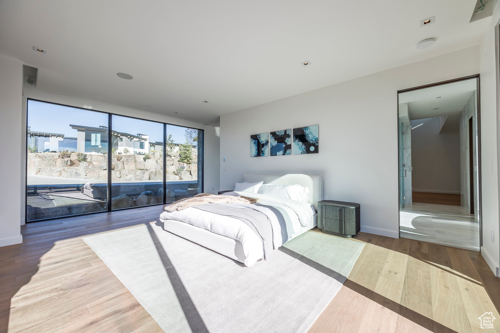 Bedroom featuring access to exterior, wood finished floors, and baseboards