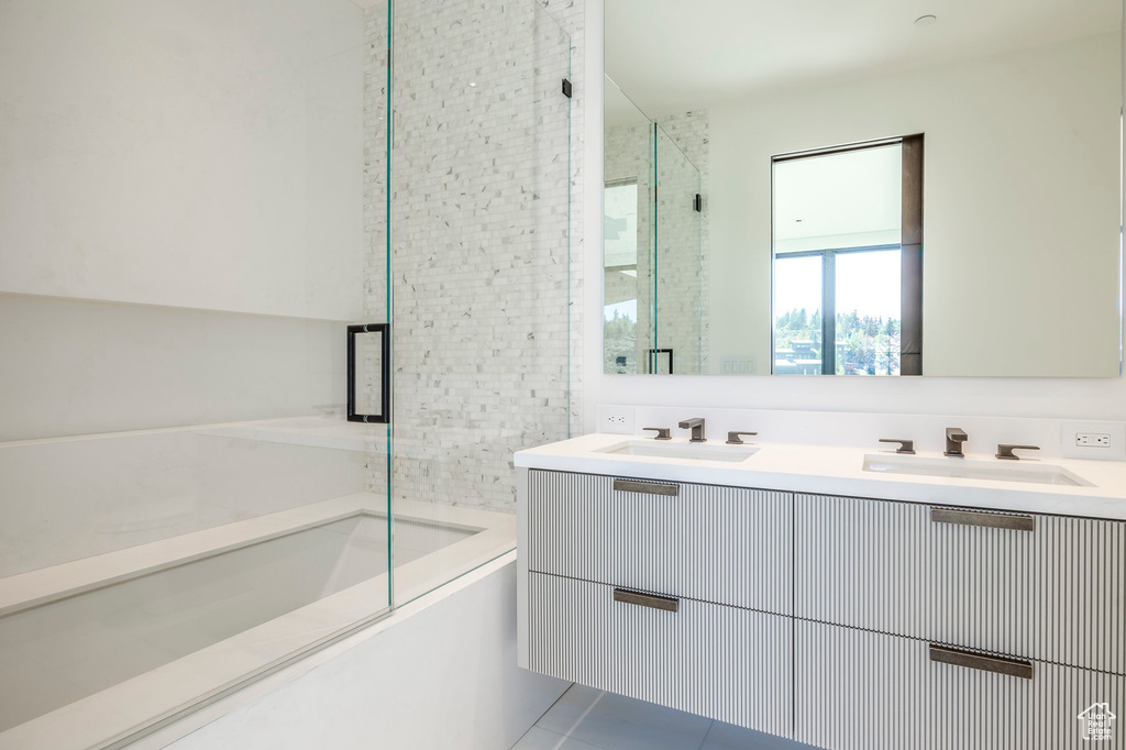 Bathroom featuring a shower with door, a bath, double vanity, and tile patterned floors