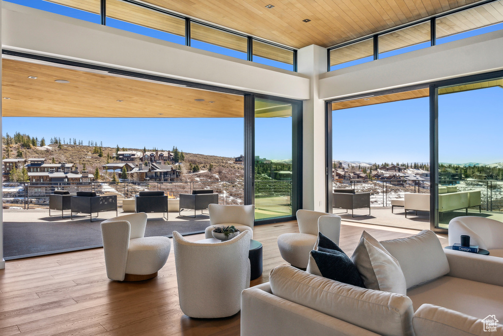 Living room with wood finished floors, a towering ceiling, and wood ceiling
