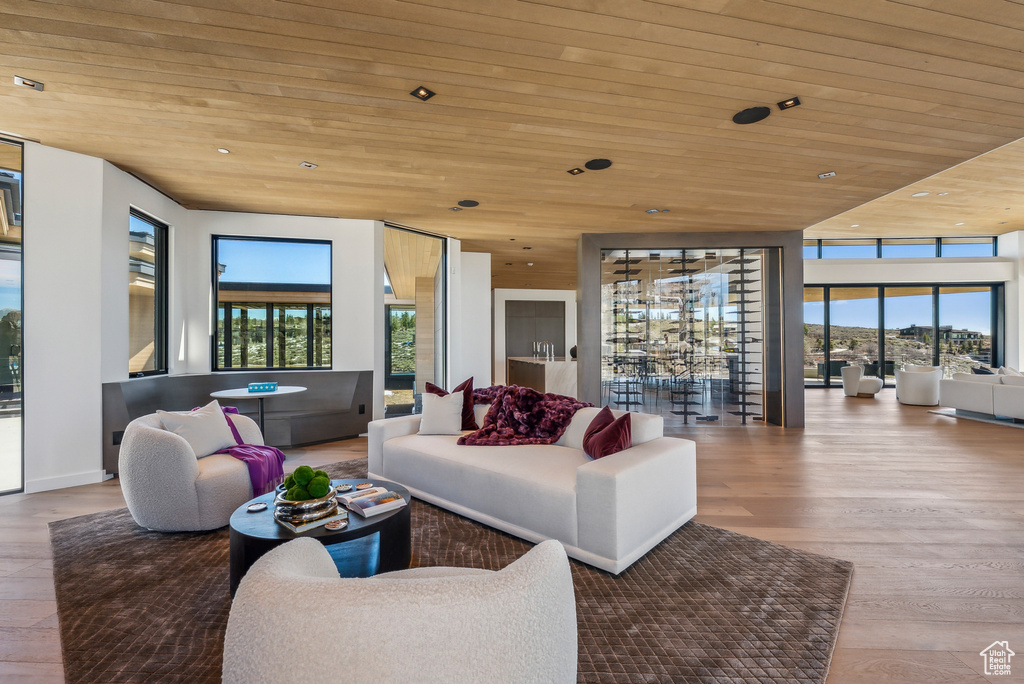 Living area with wood ceiling, plenty of natural light, wood finished floors, and recessed lighting