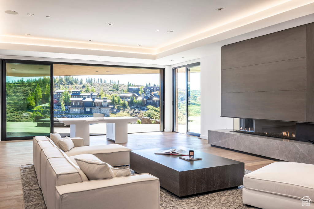 Living area featuring wood finished floors, a wall of windows, and a multi sided fireplace