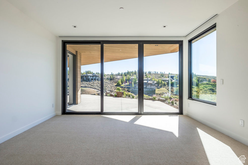 Empty room featuring carpet and baseboards