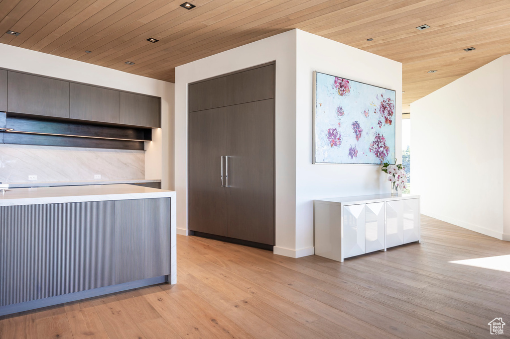 Kitchen featuring light wood-style floors, light countertops, wood ceiling, modern cabinets, and baseboards