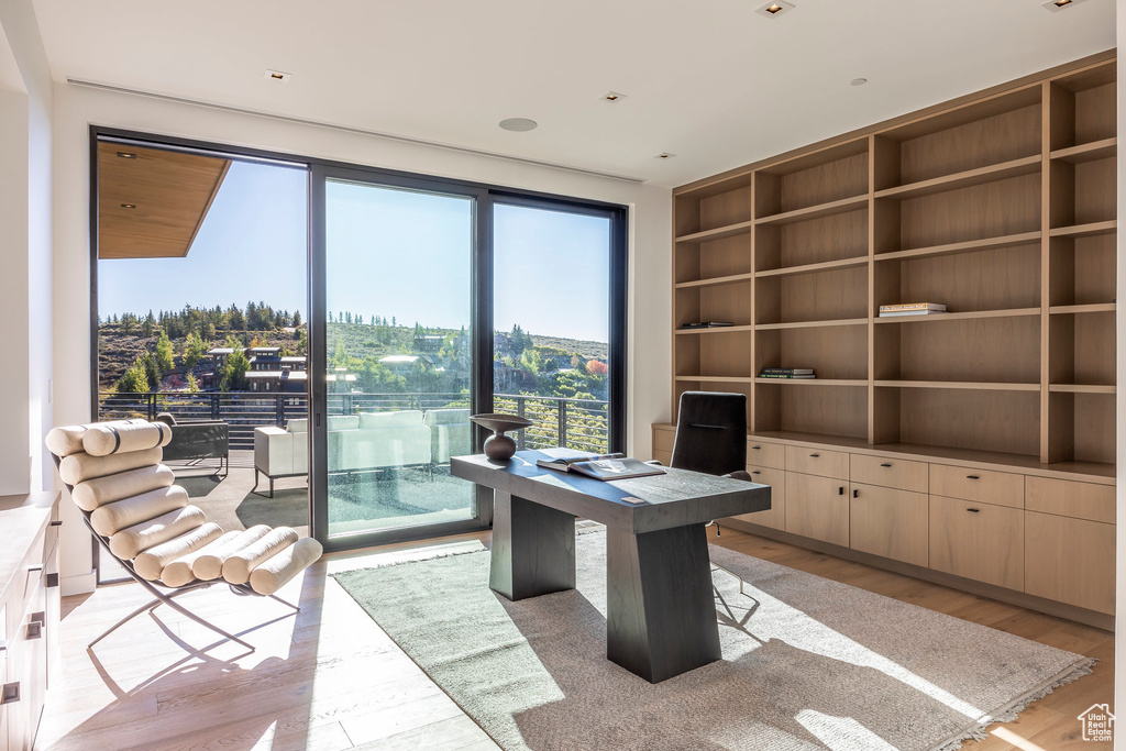 Office area with built in features and light wood finished floors